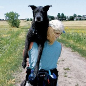 Founder holding darker dog named Blue over her shoulder